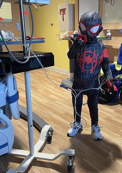 Lukas Ramos is posing in his Spider-man costume at CHRISTUS Children's