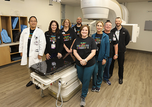 The CHRISTUS  Ochsner team stands in front of the TrueBEAM radiotherapy system